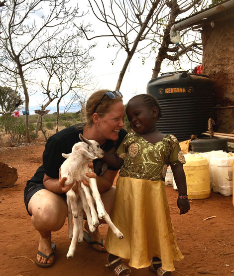 Vics holding baby goats with her namesake Victoria Joyce, Rosie's daughter in their village
