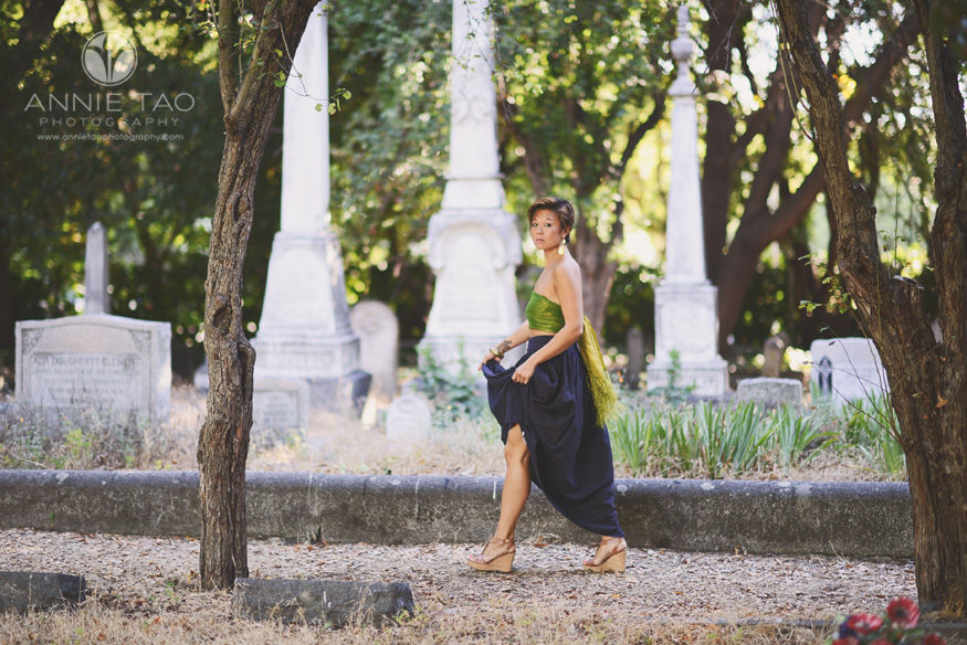 East-Bay-styled-photography-woman-holding-skirt-while-walking-through-cemetary