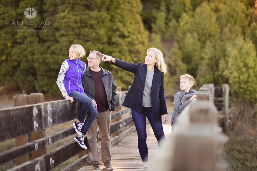 South-Bay-lifestyle-family-photography-woman-pointing-and-family-looking-while-on-wooden-bridge