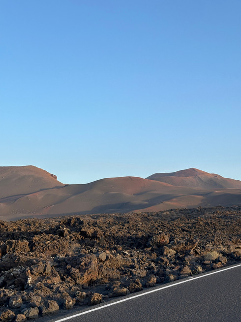 Volcanic landscape in Timanfaya National Park on Lanzarote with lava fields and craters.