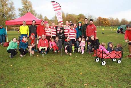 Group shot of runners in a field with kids in a trolly