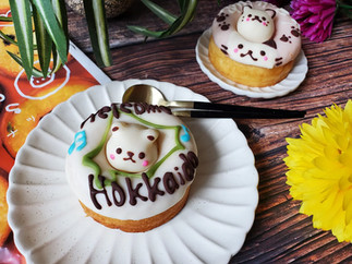 Donut decorated with bear which says 'Welcome Hokkaido' and donut that says 'arigato decorated with cats, from Siretoco Donuts in Sapporo, Hokkaido Japan.