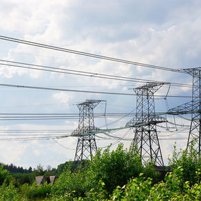 High power transmission lines crossing a landscape of low bushes.