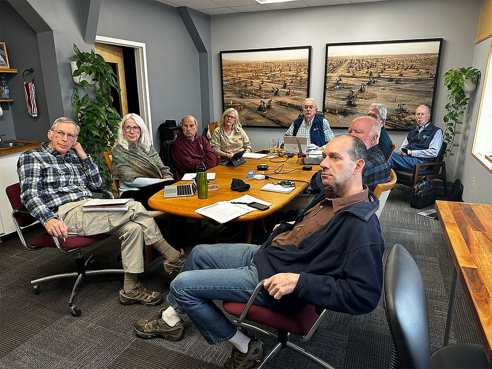 CPCNH leadership and board members gather around a conference table in the Dixon Avenue office, framed by Edward Burtynsky’s striking oil field photographs—a symbolic backdrop to discussions about clean energy and community power in New Hampshire.