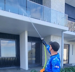 man is doing soft washing of house in Mount cotton, he is from oceanwave soft and pressure washing company from Redlands