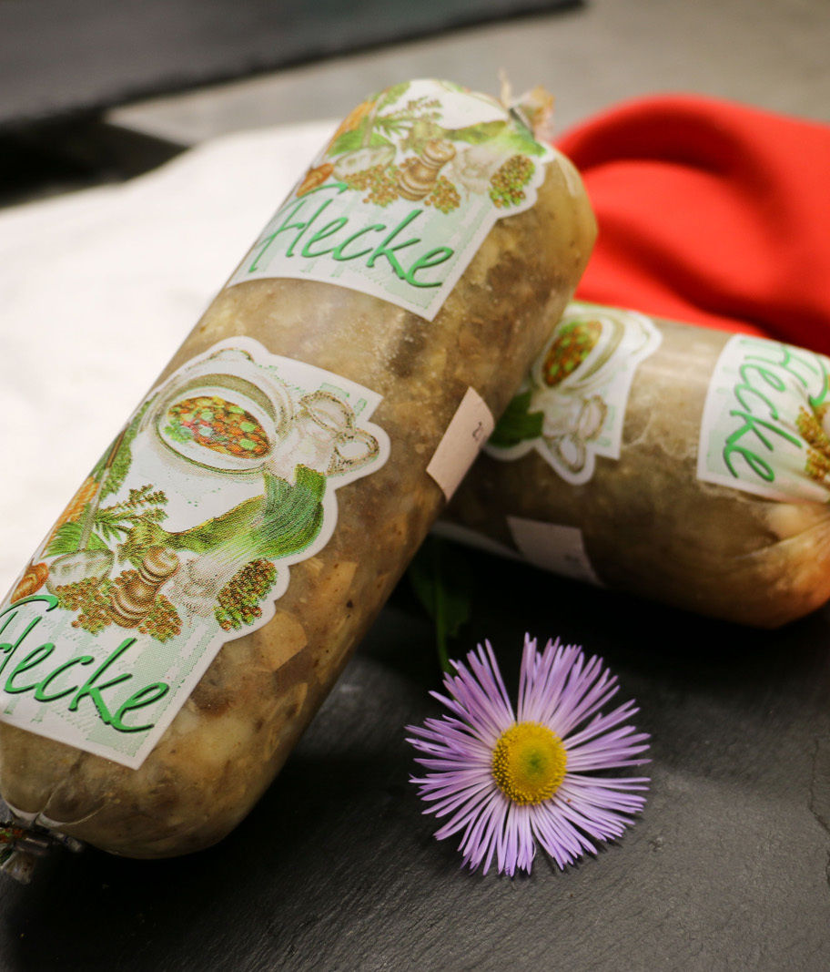 Zwei Rollen Hecke Bienenfutter neben einer lila Blüte.