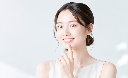 矯正後の嫌いな歯並びで、口元に指をあてて笑顔の女性