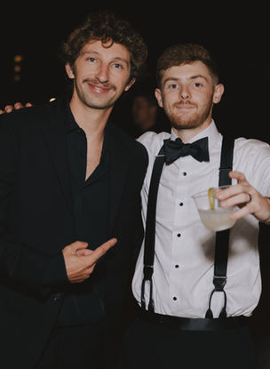 Image of groom and groomsman standing at reception following wedding ceremony in Denver, Colorado