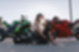 Photo of two motorcycle riders kissing in front of their bikes during motorcycle photo session with Jenna Loeva Photography