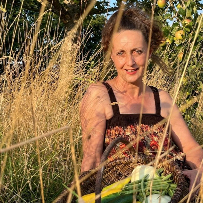 Frau im Gras mit Gemüsekorb