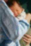 parent hugging newborn sleeping child