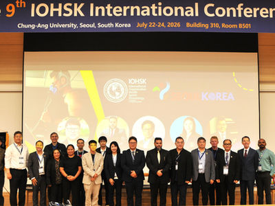Dr. Raul Calderon standing with conference speakers on stage beneath the 9th IOHSK International Conference banner at Chung-Ang University, Seoul