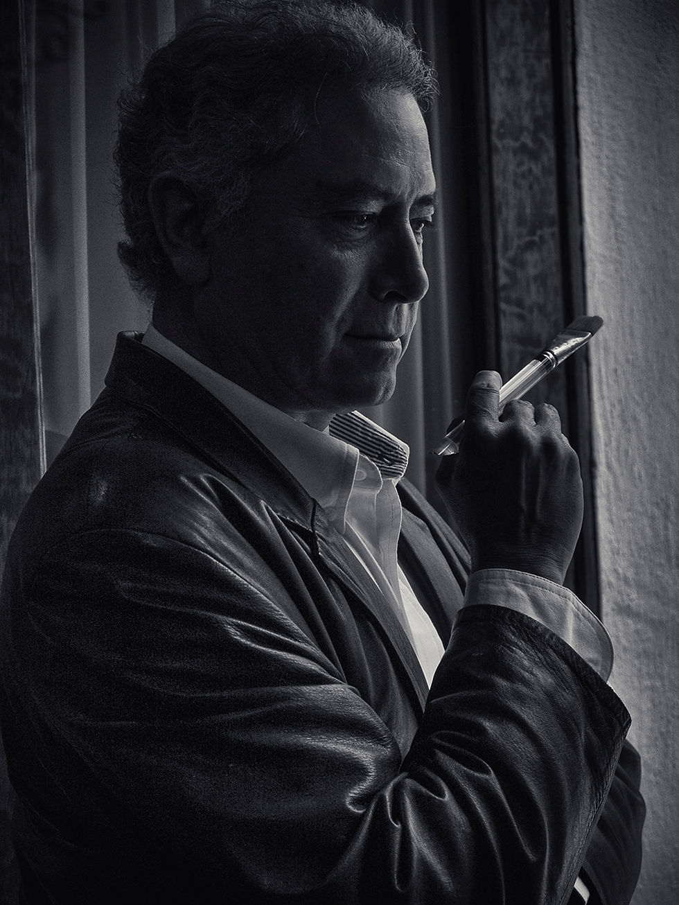 Maestro Benito Nogueira Acuarelista, sesión de retrato profesional con iluminación cálida y fondo ne