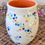 Thumbnail: Porcelain cup with orange interior glaze and rainbow polka dot exterior glaze and gold luster accents.