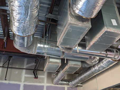 HVAC ducting in an unfinished room. It looks as if the space is being repurposed and ducting is being added.