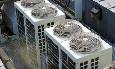 Several rooftop units that are working. There is some dust or gas hovering about the units