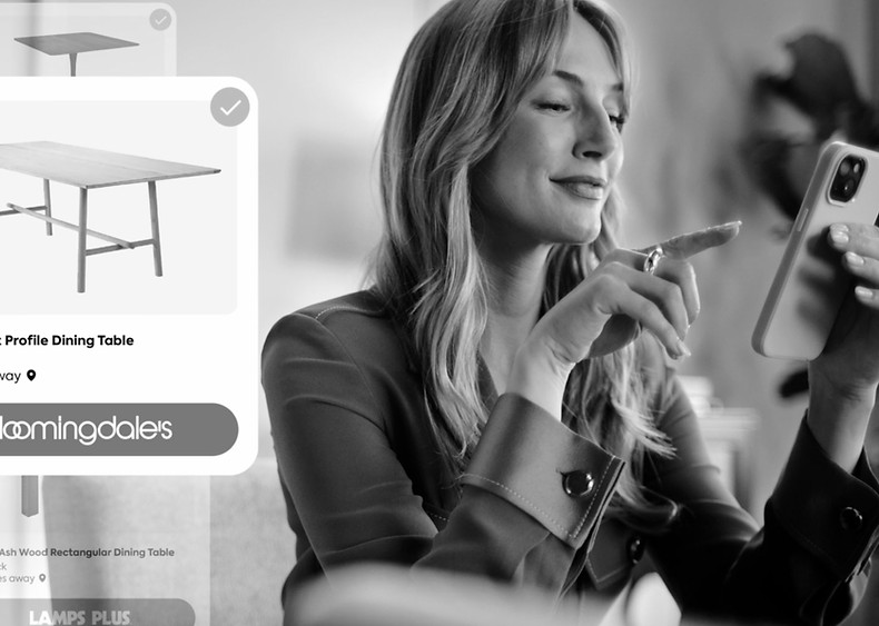 Woman scrolling on her phone in Furniture.com retail ad.