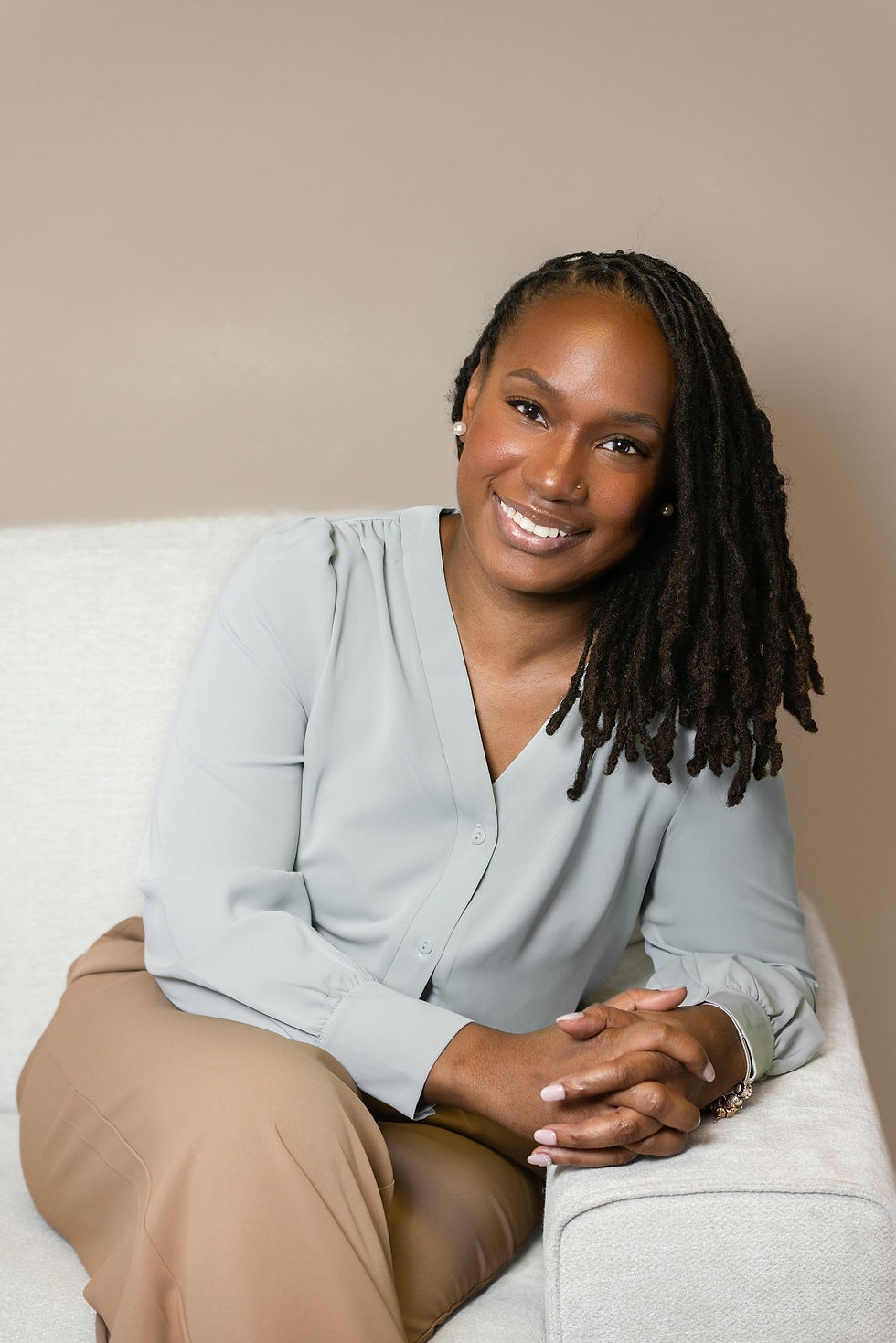 Lifestyle branding photo of therapist Keona Kelly seated on couch where she meets with clients