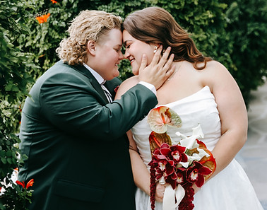 Plus size Same-Sex couple embraces sweetly in between greenery