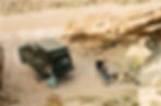 Madix camper in Moab desert with people reading around a fire pit.