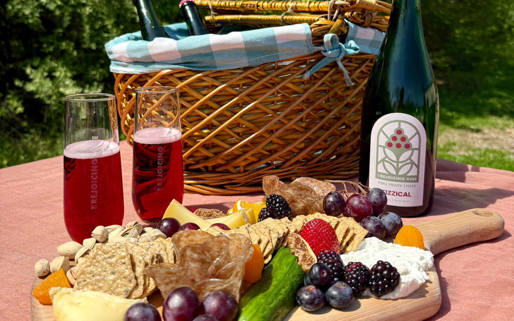 Charcuterie board and bottle of wine on a picnic setup