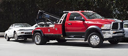 Red tow truck towing a white car