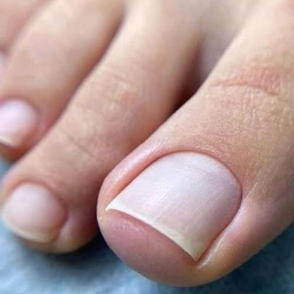 Close-up of bare toes with neatly trimmed white-painted toenails against a soft blue background.
