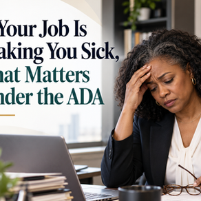 Black woman at her office desk holding her forehead and looking exhausted, illustrating how workplace stress and deteriorating health may relate to ADA protections.