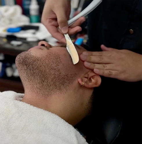 Straight razor shave using the backhand razor stroke technique to define and shape a beard, ensuring a smooth, precise finish.