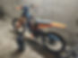 Black and orange electric dirt bike with battery pack, parked indoors.