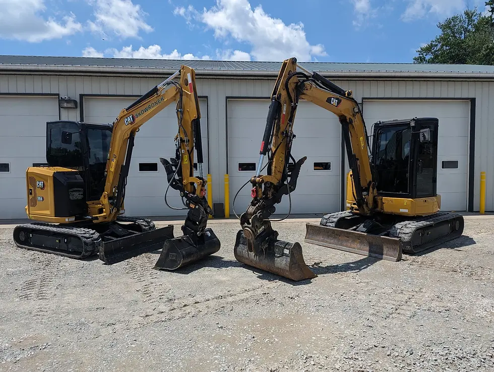 Two mini excavators staged for work in North Huntingdon, PA, by Skowronek Landscaping & Excavating.