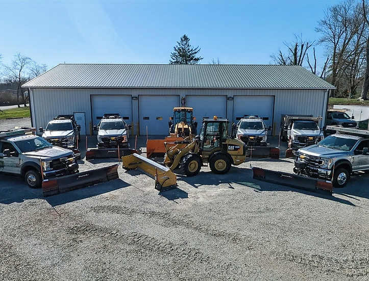 Fleet of plow trucks and loaders ready for commercial snow removal in Westmoreland County, PA, by Skowronek Landscaping & Excavating.