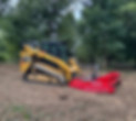 CAT skid steer with Fecon mulcher attachment clearing land in Irwin, PA by Skowronek Landscaping & Excavating.