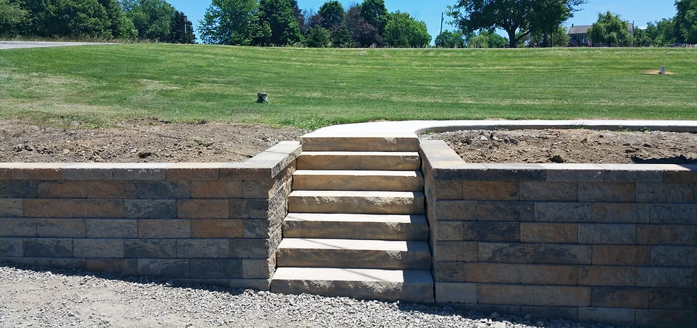 Retaining wall installation in Irwin, PA with stone block steps and landscaping by Skowronek Landscaping & Excavating.