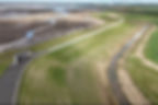 View of the new embankment with intertidal habitat in the background, and a bird hide near the eastern end of the scheme - Environment Agency