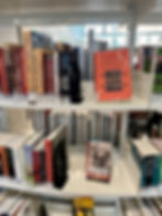 Austin Public Library curated special collection of books about Texas history, particularly Juneteenth on the top shelf with the orange cover of Juneteenth Texas on prominent display with the cover facing outward on the far right side of the shelf.