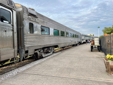 Old silver Amtrak train cars ready to board in the rail yard