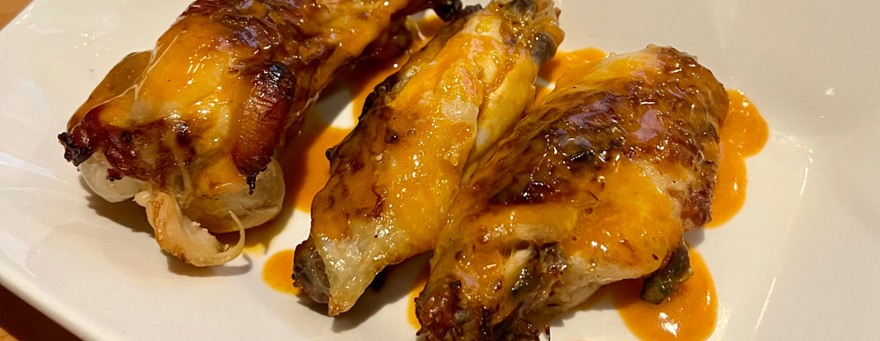 3 chicken wings with drizzled with buffalo sauce