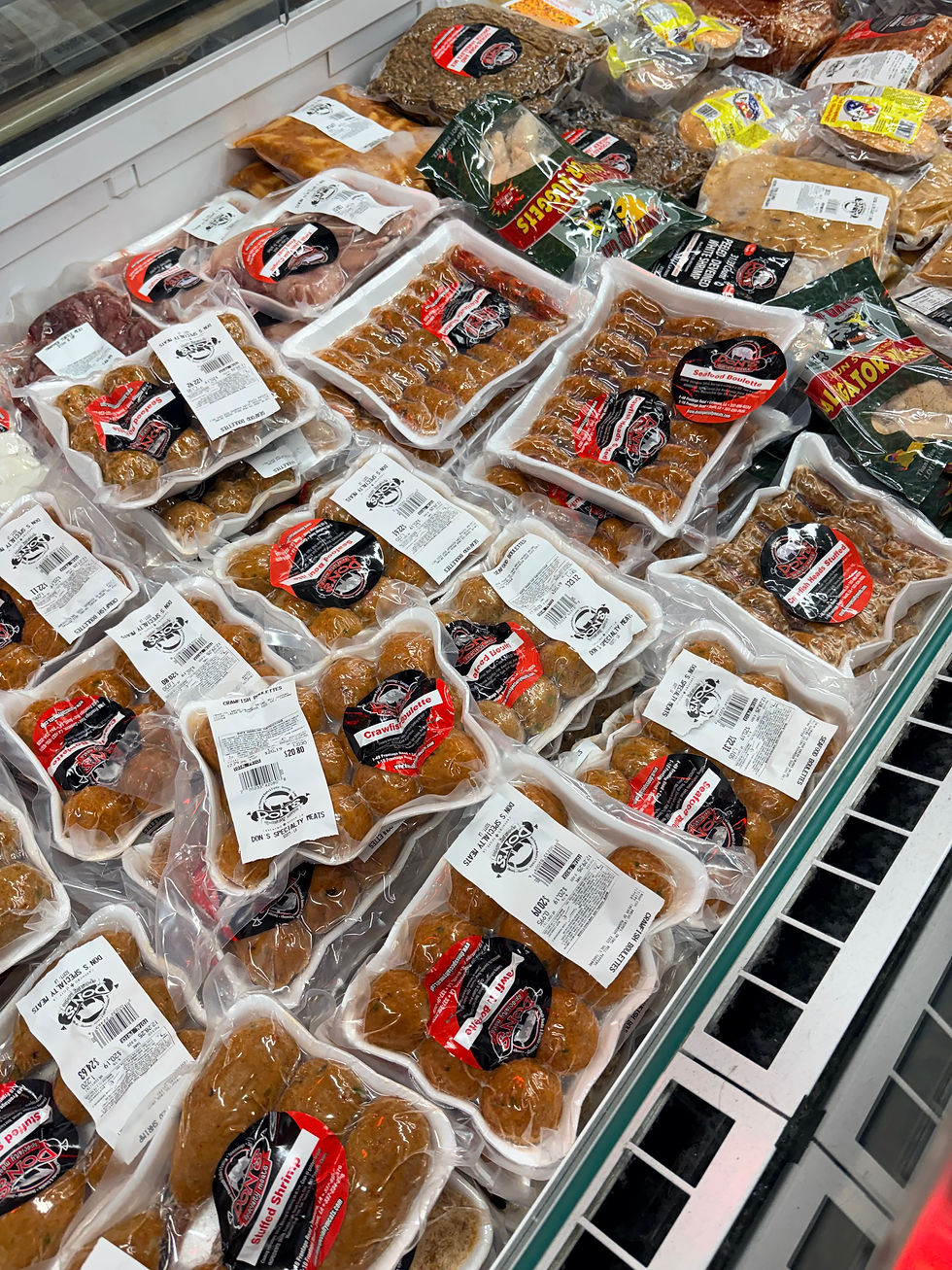 Packaged boudin in a grocery store display, with clear plastic wrapping and red, white, and black labels. Variety of meats visible.