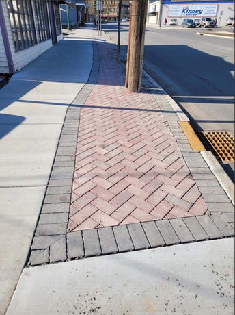 a close-up view of a brick sidewalk featuring a classic brick pattern in warm tones