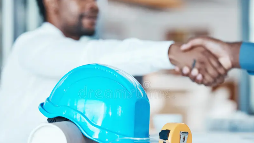 A seafarer shaking hands with a recruiter, standing beside a shipping vessel.