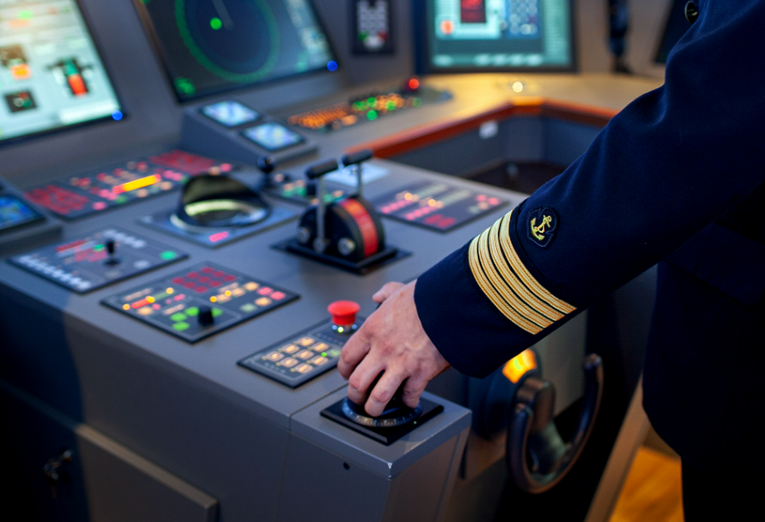 Deck officer reviewing CoC/CoE documentation at a maritime counter.