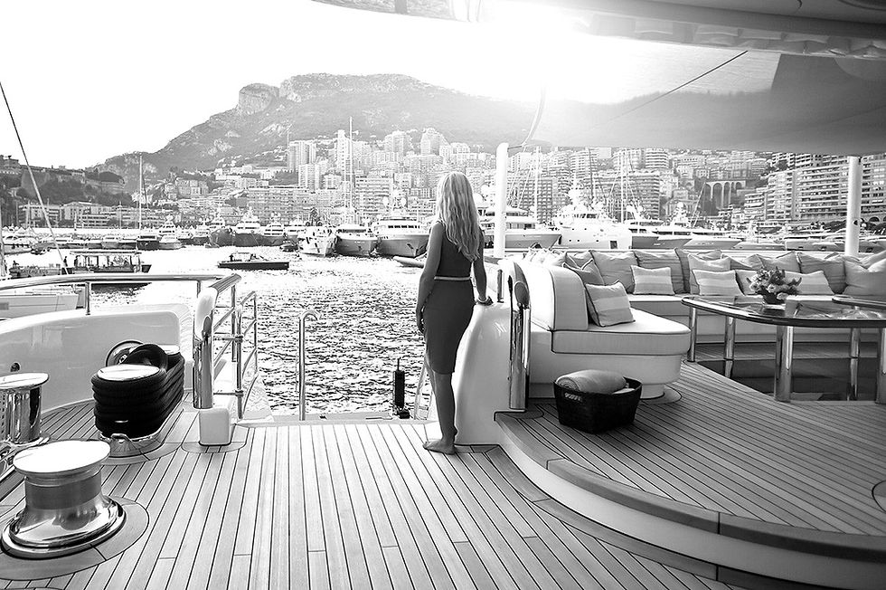 woman looking from a yacht to the shore of monaco