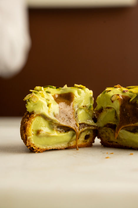 Pastry filled with green cream, cut in half.