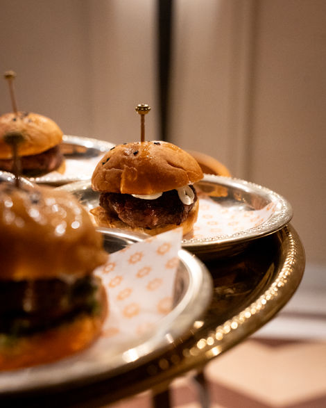 Mini burgers on a silver tray.