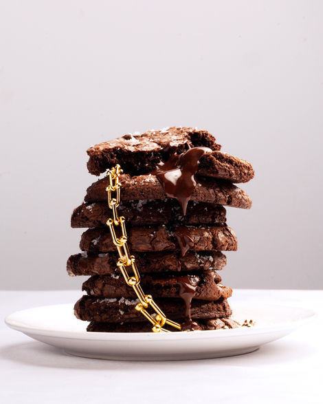 Stack of chocolate cookies with a gold chain.