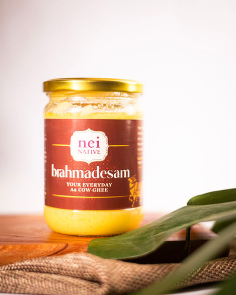 Jar of Brahmadesam cow ghee on wooden surface.