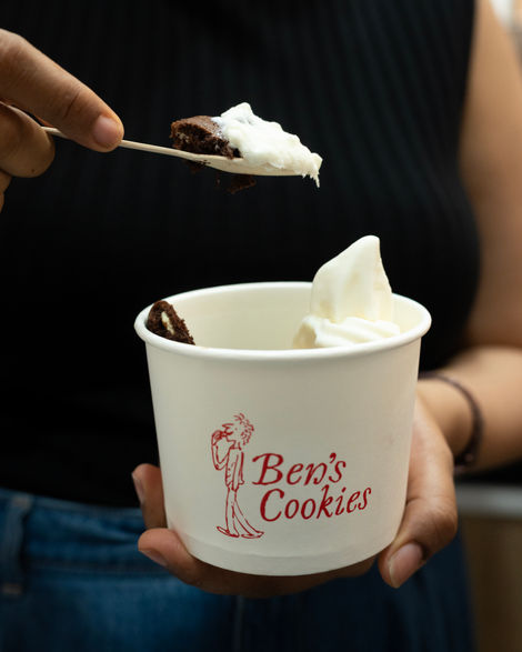 Person holding Ben's Cookies cup with dessert.