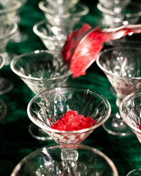 Red dessert being served into glass dishes.