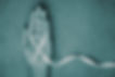Stretched out hand with a crossed over ribbon with a teal filter, the colour for sexual assault awareness and prevention.